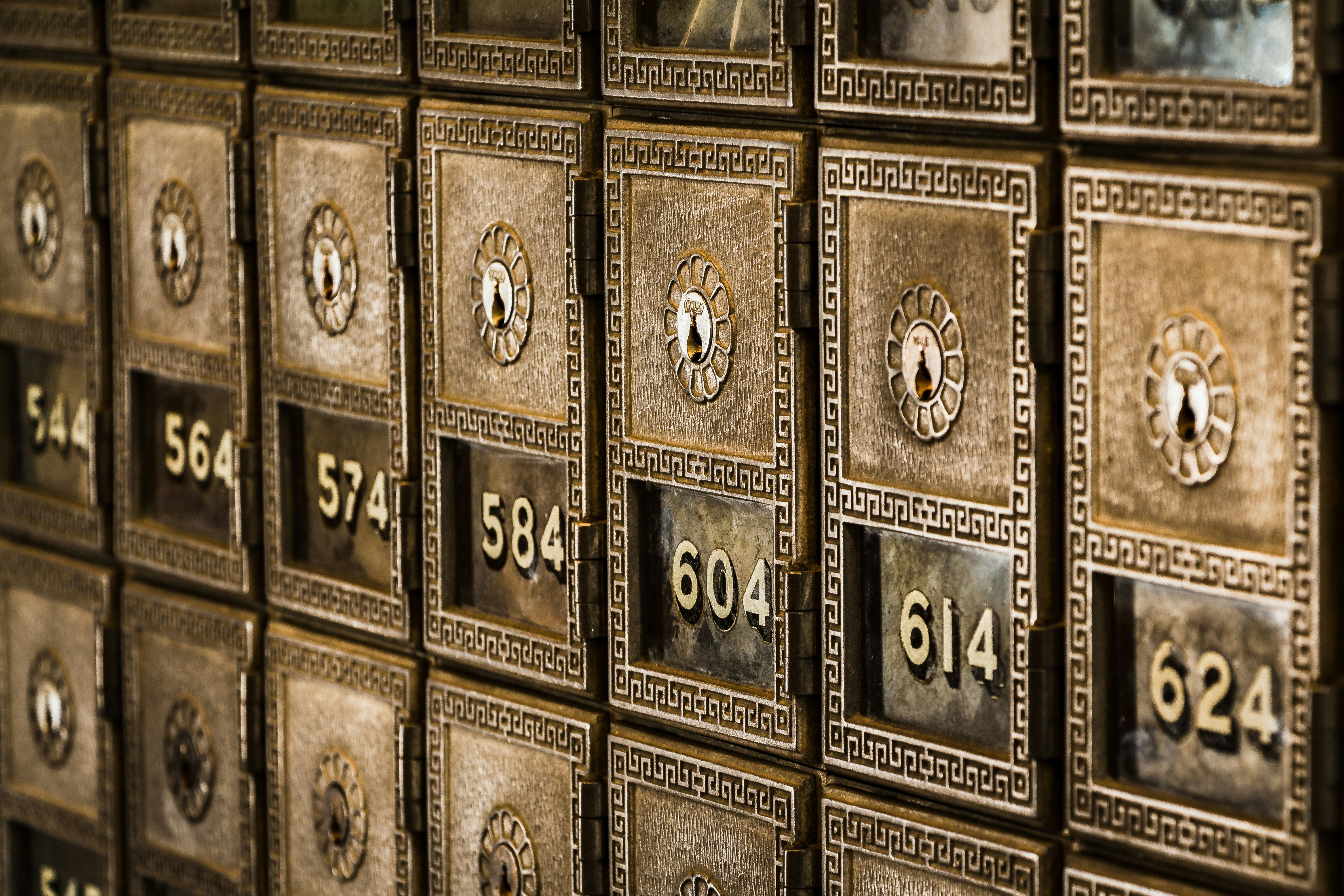 Wall of old gold-colored metal mailboxes