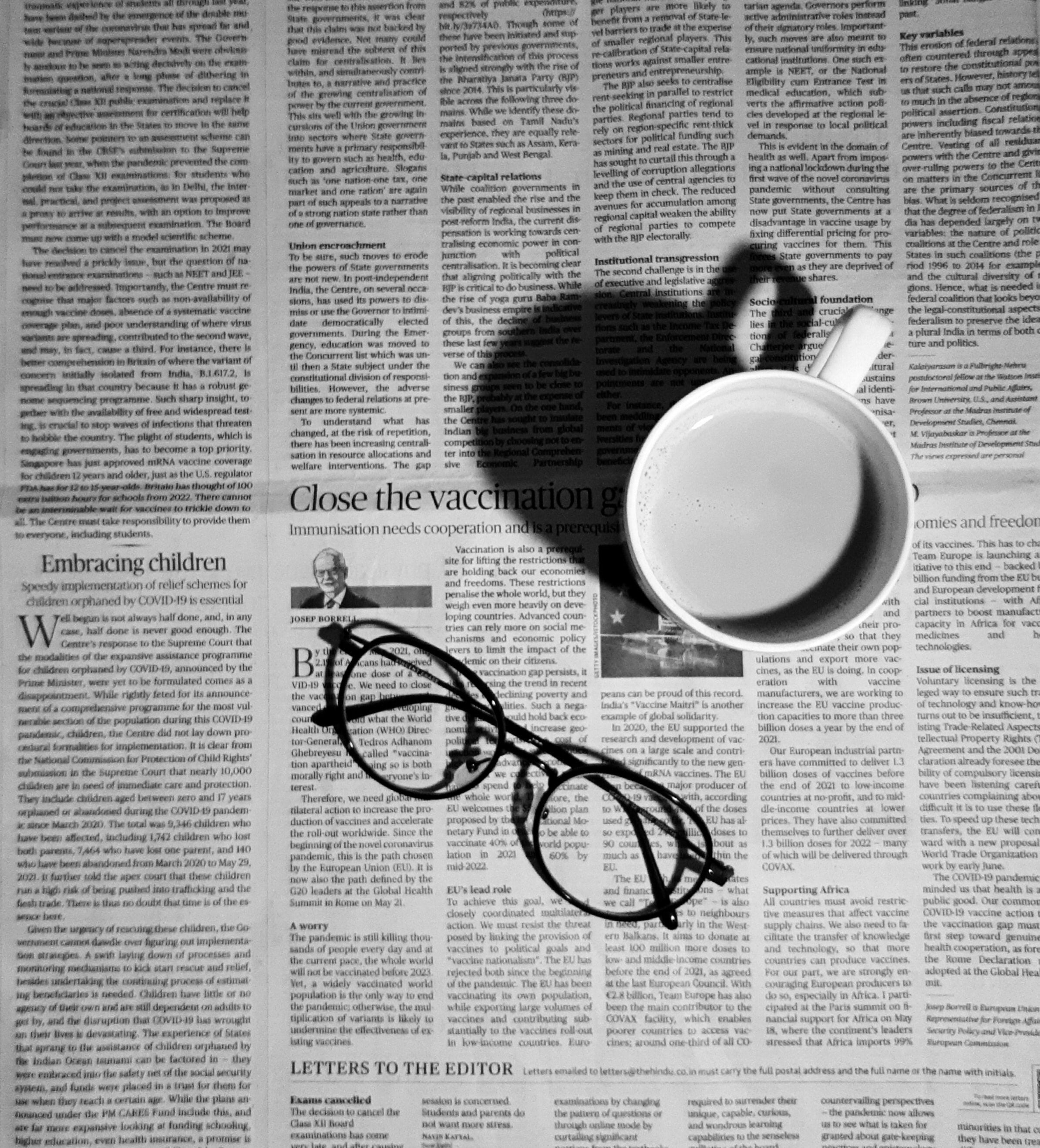 cup and glasses on newspaper