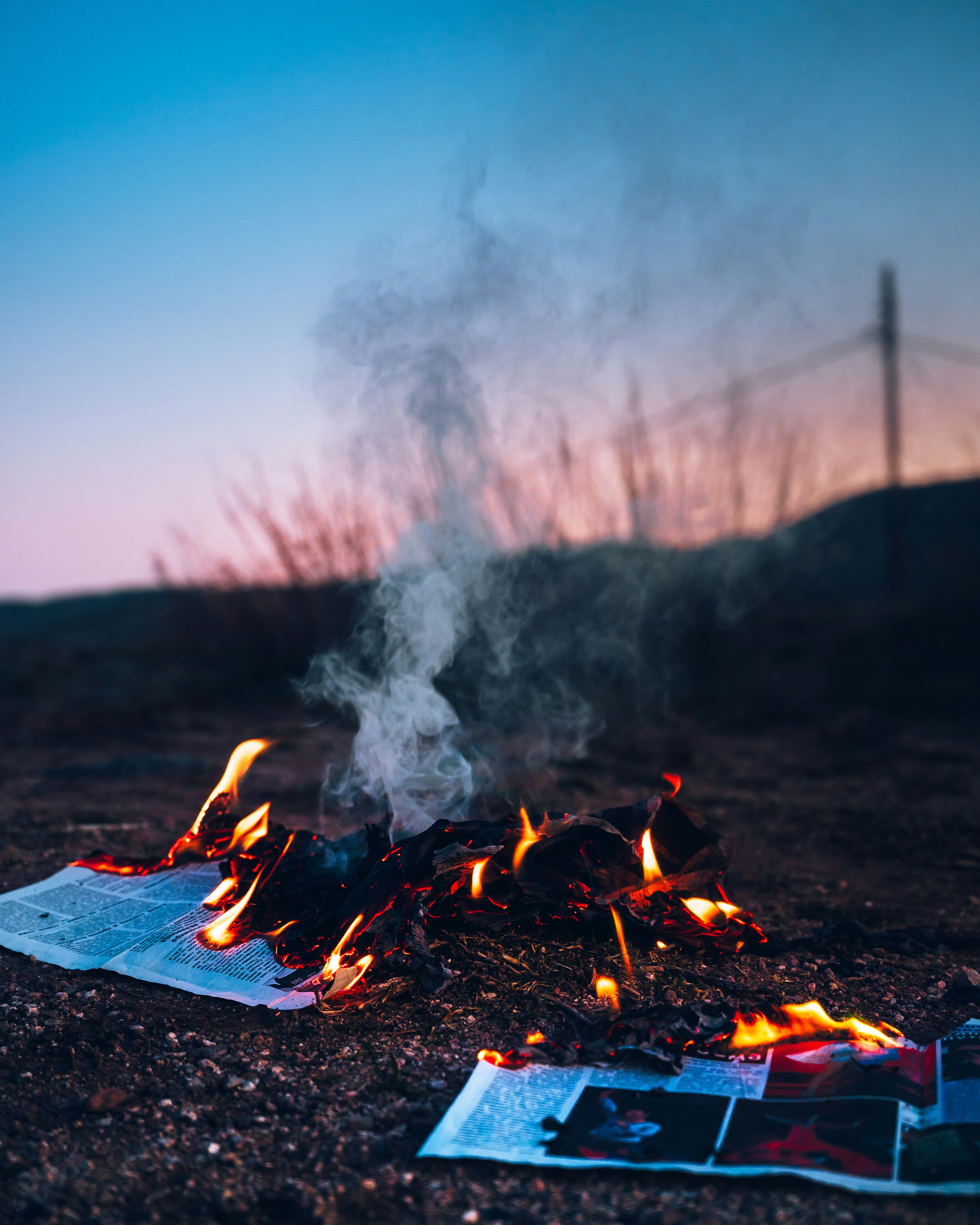 Image of a book in flames under a blue sky